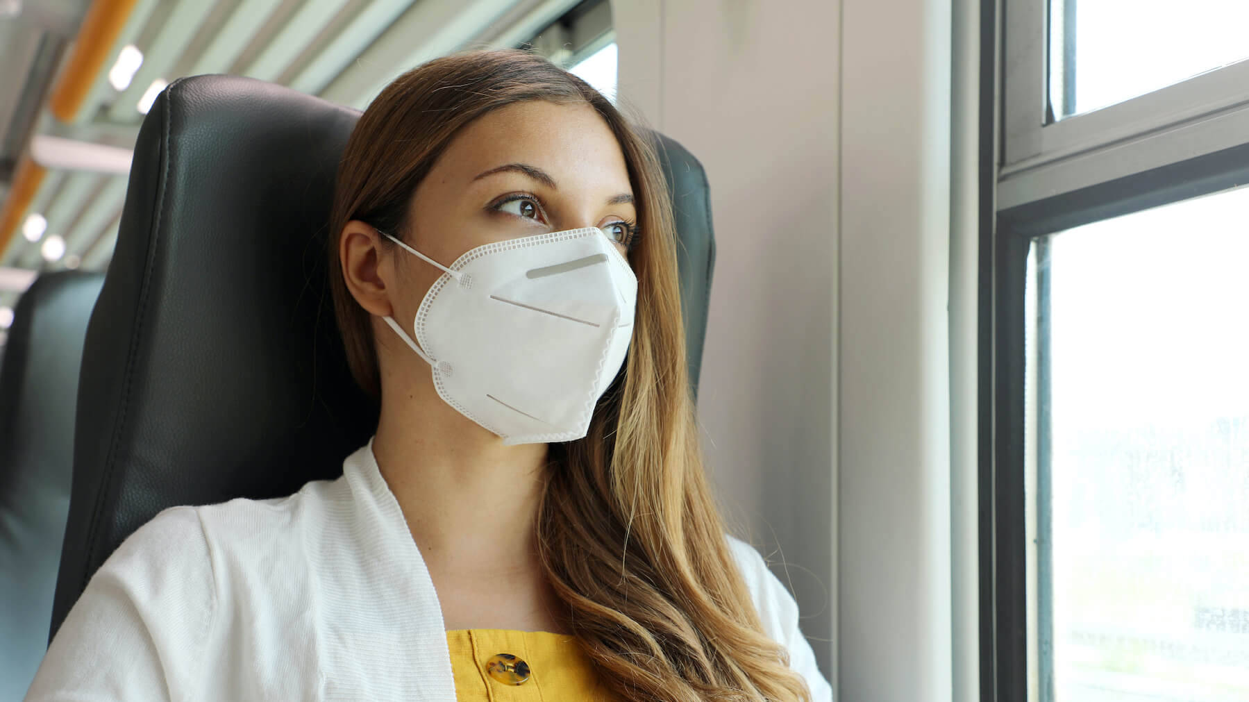Frau trägt FFP2-Maske in der Bahn