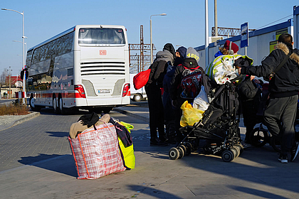 Ukrainische Geflüchtete vor einem DB Regio Bus