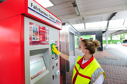 Mitarbeiterin des Hochbahn-Hygieneteams reinigt Fahrkartenautomaten